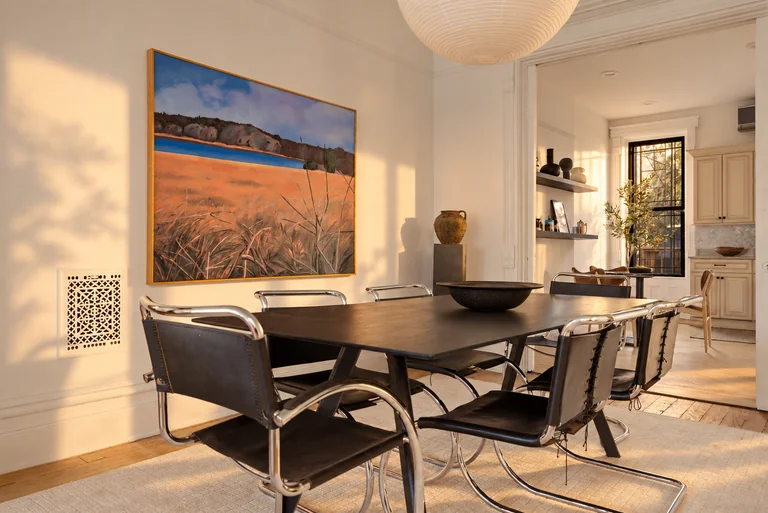 Dining room with a black table, chrome chairs and landscape artwork at 731 Putnam