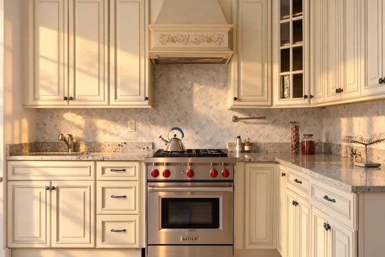 Kitchen range and cream cabinetry with a decorative hood at 731 Putnam