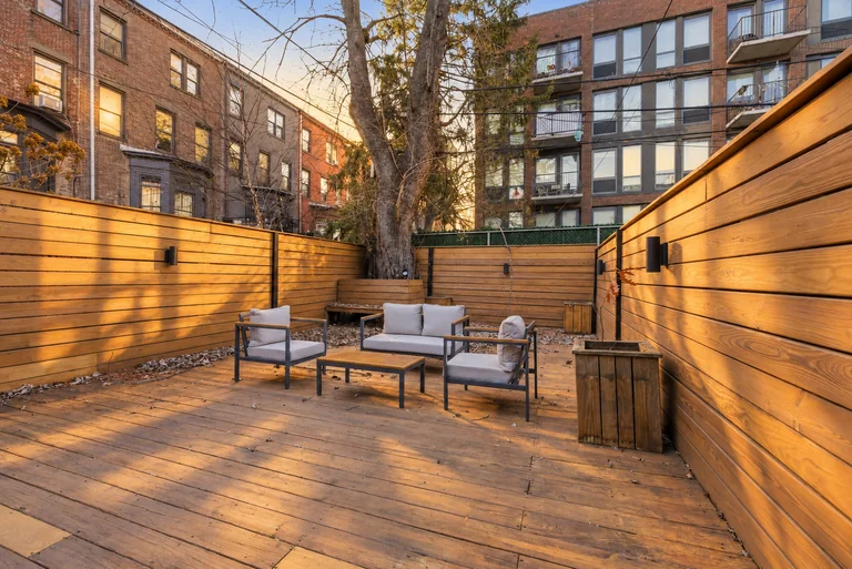 Wide view of the wood deck, patio seating and surrounding buildings at 731 Putnam