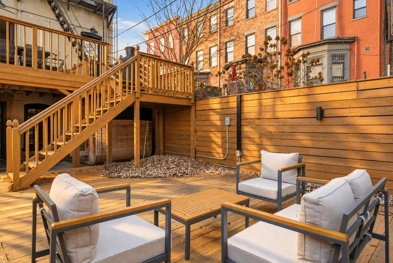 Patio seating facing the wood stairs and deck railings at 731 Putnam