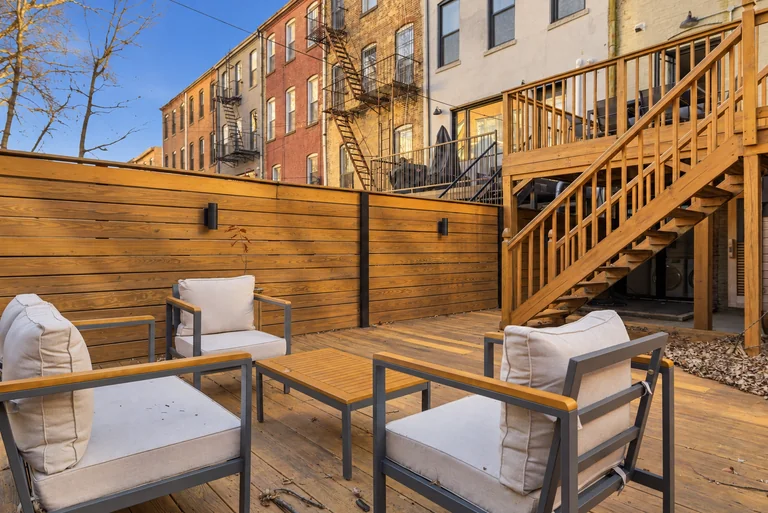 Outdoor chairs and table beside the wood staircase at 731 Putnam
