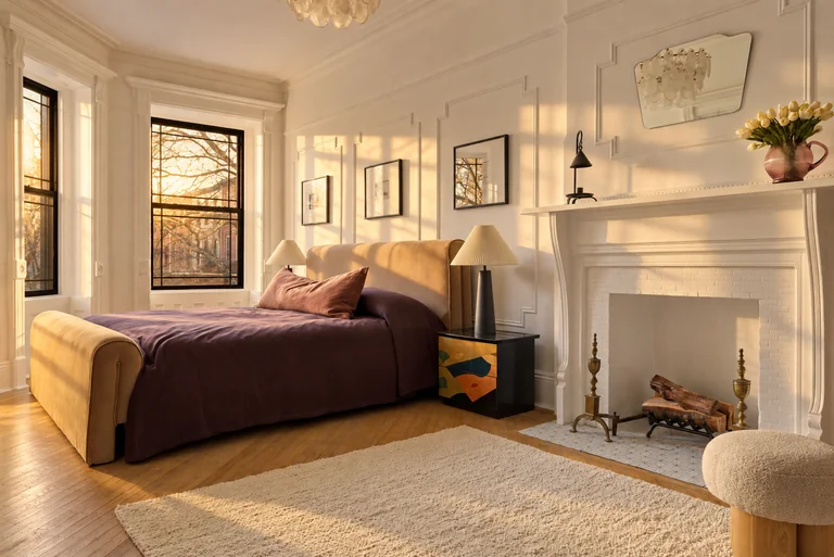 Bedroom with purple bedding, white fireplace and black-framed windows at 731 Putnam