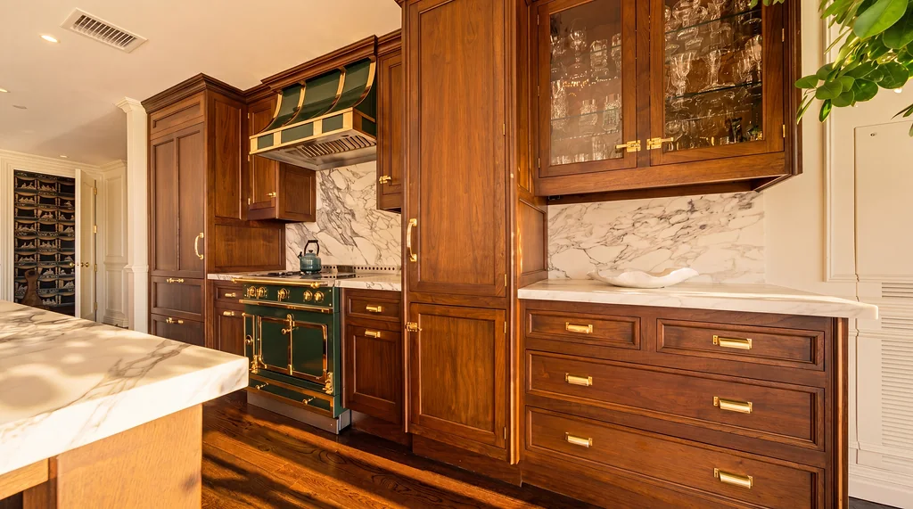 The Visionaire kitchen with green range, marble backsplash, and wood cabinetry